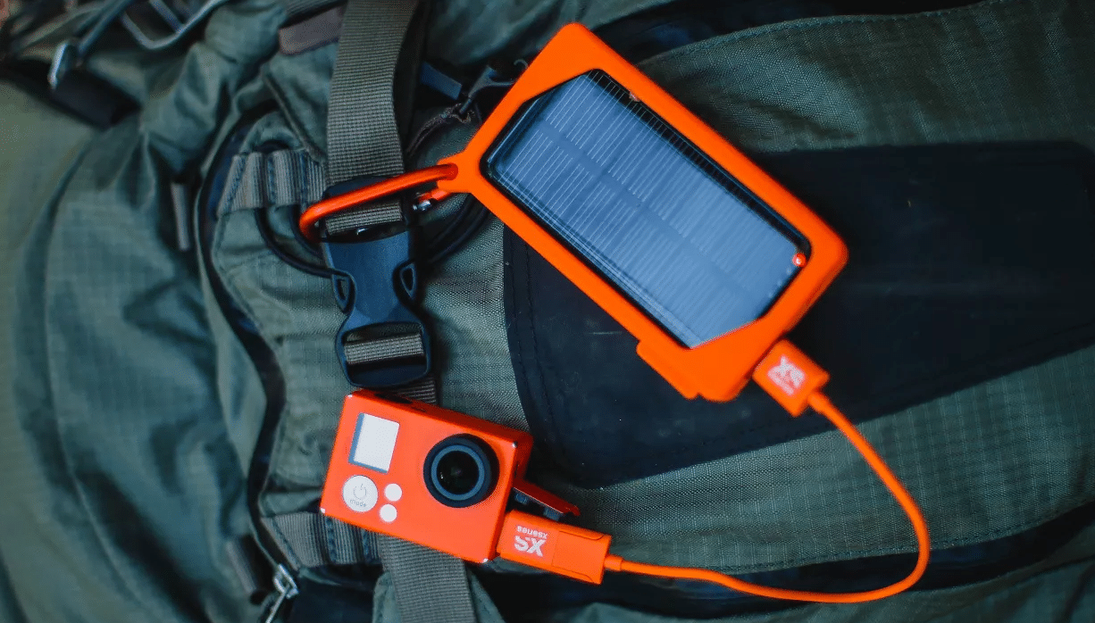 Outdoor pictures of the XSories XSolar Charger hooked to a bag and recharging under the sun with a solar charger and power bank with solar panel