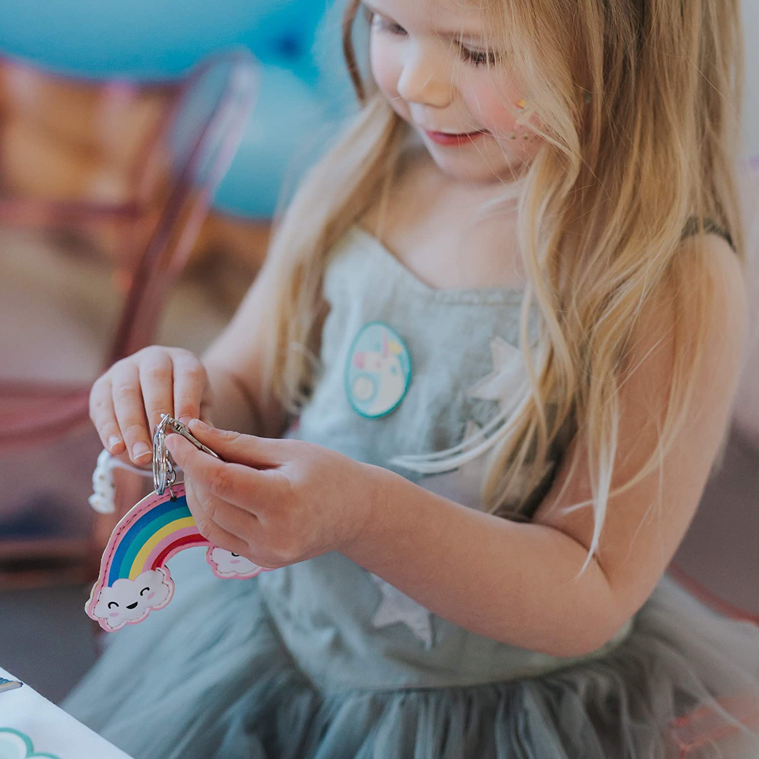 a kid girl playing with her rainbow keyring